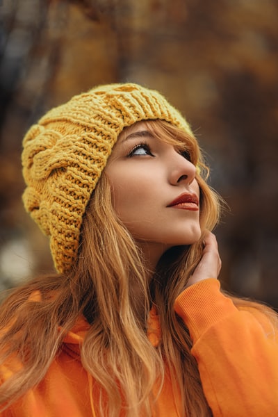 女人用黄色无檐小便帽帽子和橙色的运动衫
